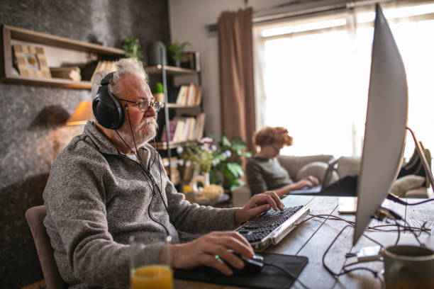 istock grandfather and grandson sitting around table at home and using computer 1453311348
