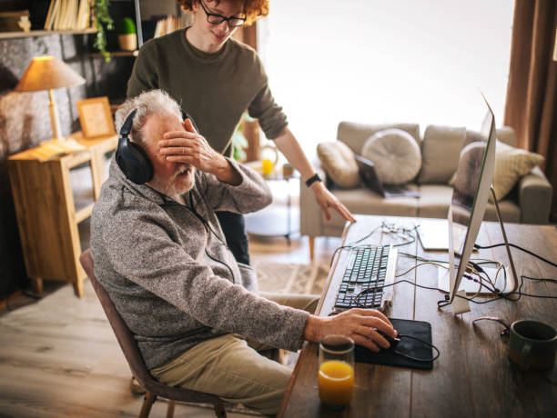 istock grandfather and grandson sitting around table at home and using computer 1453311350