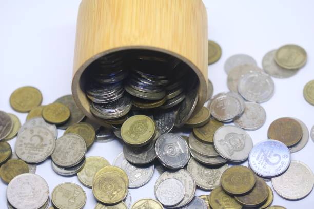 istock multiple color shape and valued spilled Sri Lankan rupee coins with a wooden container is isolated on white 1453313640