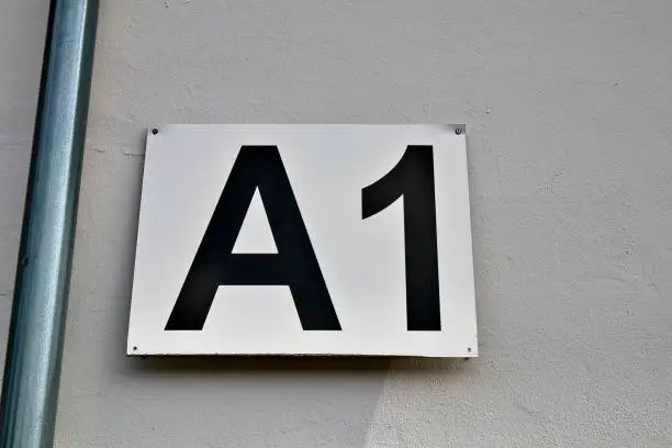 A closeup shot of the entrance gate sign and number A1 of the stadion's white wall