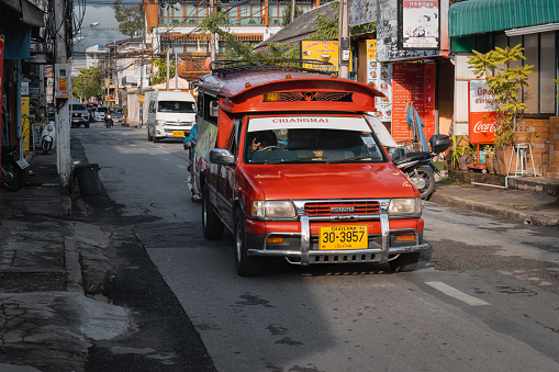 Chiang Mai, Thailand. November 18, 2022. Songthaew or 'red car'. Traditional taxi on the street of Chiang Mai