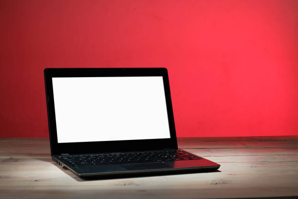laptop with a clean white screen on the table and a red background