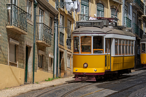 Vintage yellow retro tram in the historic city center of Lisbon.