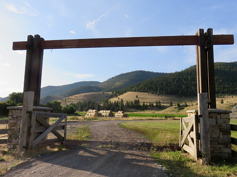 Stone columns support the ranch gate and split rail fence