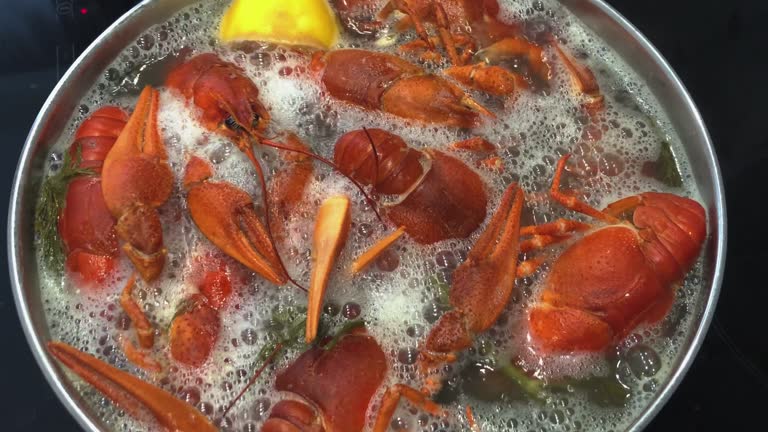 Fresh crayfish are boiled in water with seasonings close-up.