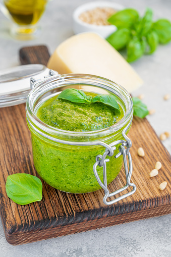 Healthy green antioxident smoothie in a glass jar containing a variety of fruits and vegetables: kale,apple, spinach, broccli, parsely, kiwi, mint,avacado, and banana..