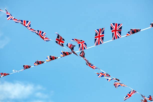 istock Low angle of the Great Britain flag bunting crossing on blue sky background 1453324852