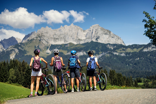 Mother and three teenage kids are enjoying a bike trip together in Austrian mountains.\nCanon R5