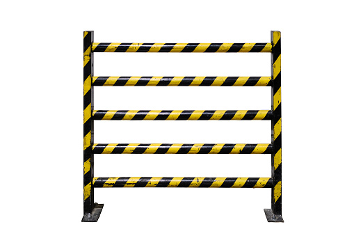 A protective yellow-and-black barrier, near a dirty white wall, isolated on a white background. Concept of quarantine and protection from coronavirus