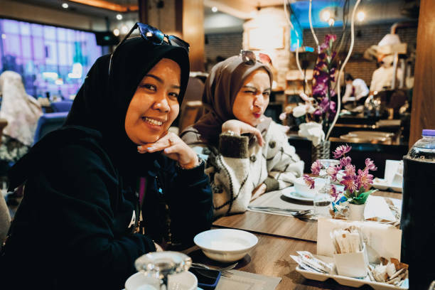 asian women enjoying dinner in restaurant asian women enjoying dinner in restaurant hari raya family stock pictures, royalty-free photos & images