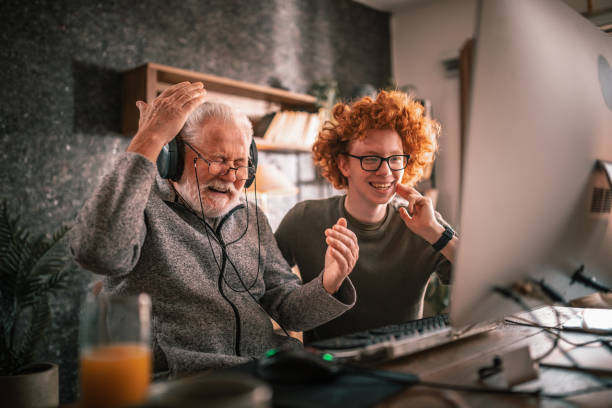 istock grandfather and grandson sitting around table at home and using computer 1453326559