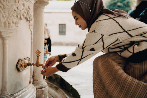 muslimische frau nimmt waschung zum gebet - istanbul people faucet turkey stock-fotos und bilder