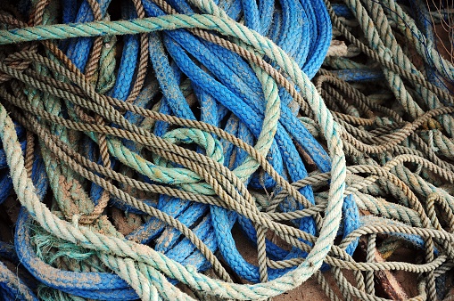 A bunch of colorful tangled fishing ropes covering the deck of the ship