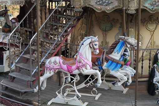 White plastic horses of a carousel in a funfair in Paris, France