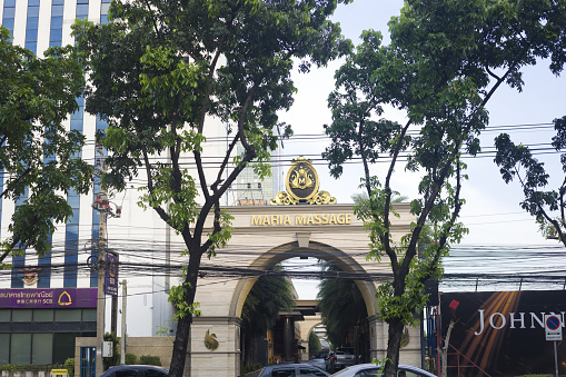 Thai massage entertainment Maria Massage for adults seated at Ratchadaphisek Rd in Bangkok Huai Khwang.  view over street through entrance gate and driveway