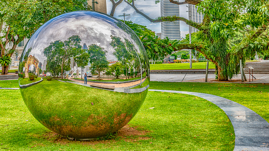 Two spherical sculptures immersed in the vegetation of a park in Singapore.