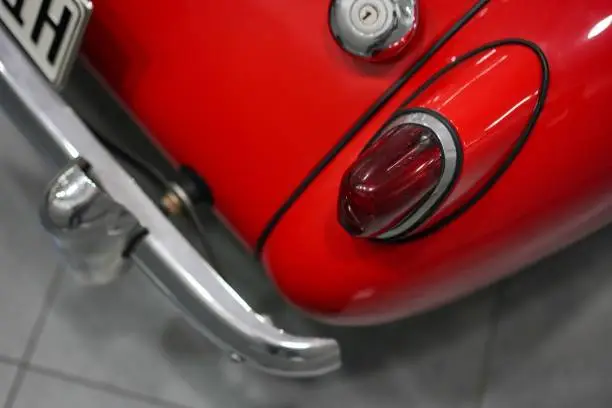 A closeup of red retro volkswagen beetle car headlight