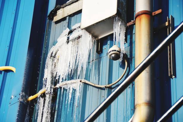 Low angle view of blue wall,ice and security camera