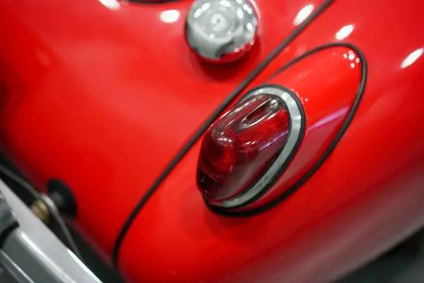 A closeup of red retro volkswagen beetle car headlight