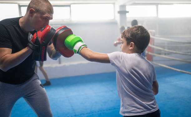 istock Group Of Kids Practicing With Instructor Boxing At Gym 1453334037