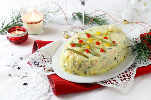 Russian traditional salad Olivier with vegetables, meat and mayonnaise. Directly above. Christmas decoration.