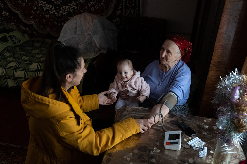 La mujer y su hija visitaron a su abuela para medir su presión arterial. photo