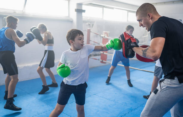 istock Group Of Kids Practicing With Instructor Boxing At Gym 1453338110