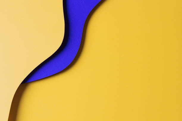 istock Abstract colored paper texture background. Minimal paper cut style composition with layers of geometric shapes and lines in yellow and blue colors. Top view 1453338371