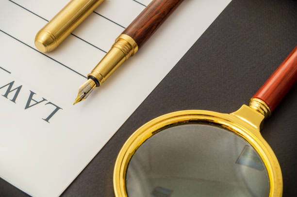 istock Office still life on a black table with pen on sheet and magnifying glass 1453340877
