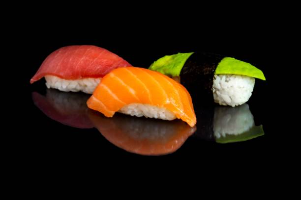 istock Mackerel, salmon and avocado sushis isolated on a black background. 1453347557