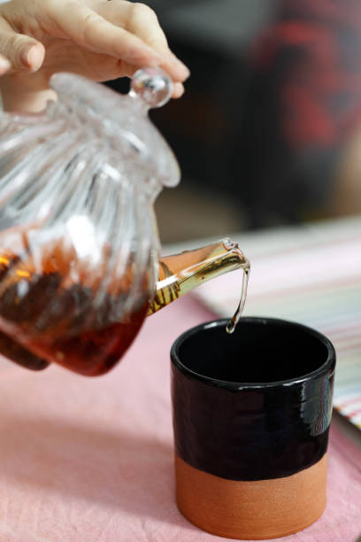 istock Woman pouring tea into the clay cup 1453349754