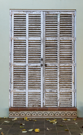 White Mallorcan shutter door closed with a padlock. Conceptual image of the real estate crisis