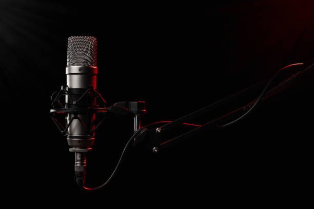 istock Large diaphragm microphone for podcast on black background with red light 1453354387