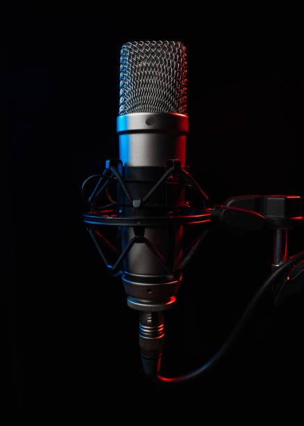 istock Large diaphragm microphone for podcast on black background with red light 1453354389