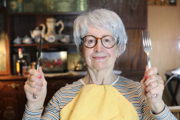 istock Senior woman holding knife and fork 1453355428
