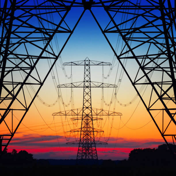 Electric coloured sky symmetric view of power pylons against a beautiful coloured evening sky kilowatt stock pictures, royalty-free photos & images