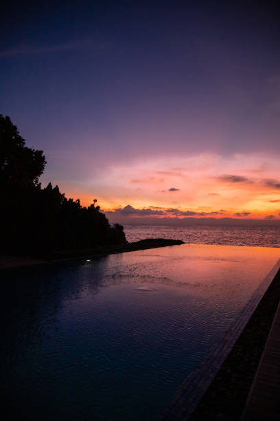 istock Romantic colorful sunset at infinity pool with sun reflection on water on tropical island in the maldives 1453359456