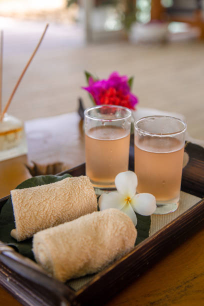 꽃이있는 아시아 웰니스 스파에서 환영 음료 차와 차가운 수건 - relaxation bali spa treatment frangipani 뉴스 사진 이미지