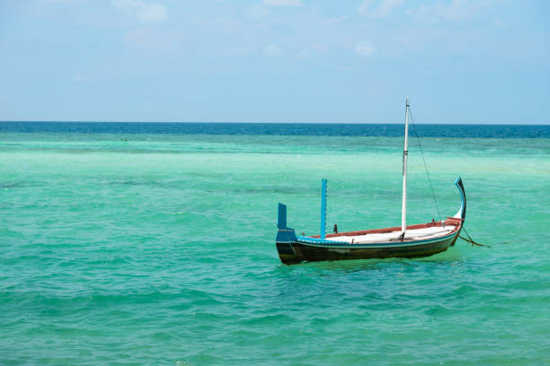 Maldivian traditional Dhoni Boat floating in blue lagoon
