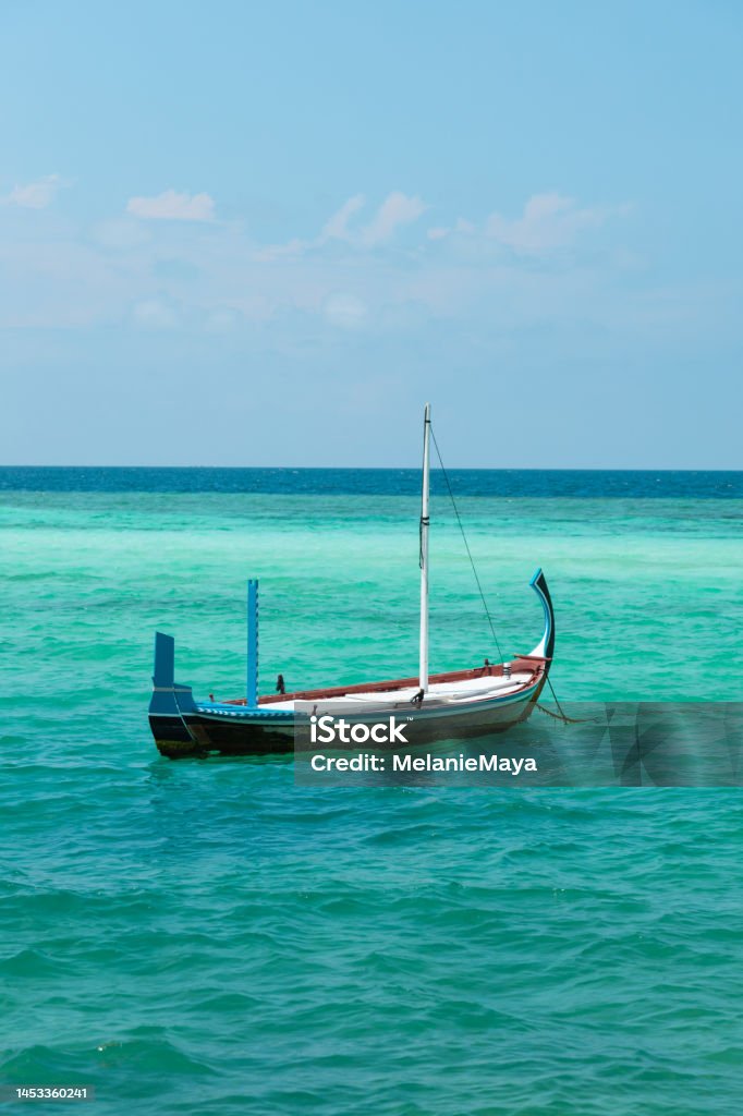 Maldivian traditional Dhoni Boat floating in blue lagoon Sea Stock Photo