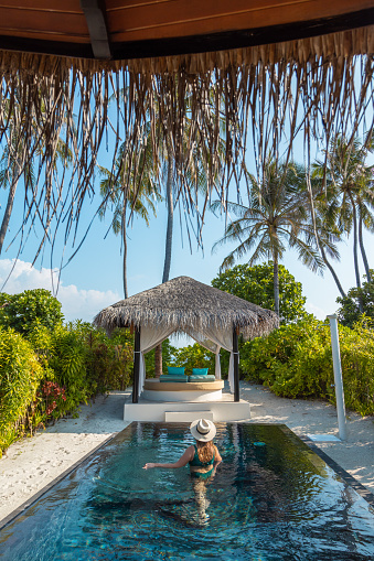 woman swimming in Maldives hotel villa with swimming Pool on tropical Island Resort