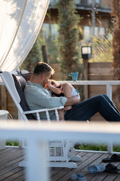 istock Father Hugging Son Sitting On Outside Home 1453361322