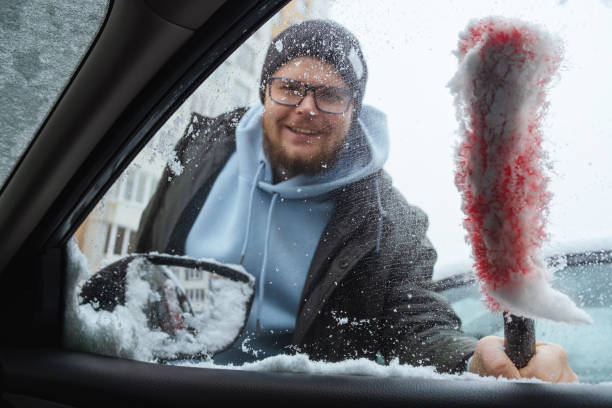 istock Winter is approaching, snowfall is expected, a man cleans the car from snow 1453363081