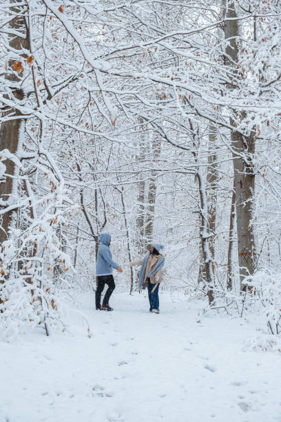 istock A couple is walking through the winter forest. 1453363101