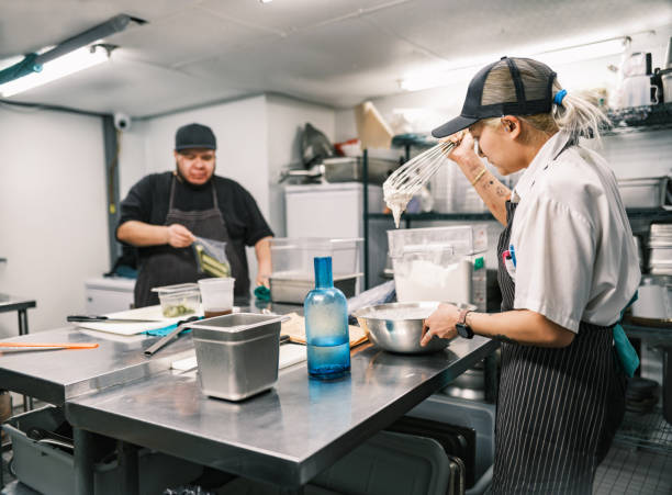 dois jovens chefs que trabalham na cozinha do restaurante - asian ethnicity chef fine dining creativity - fotografias e filmes do acervo