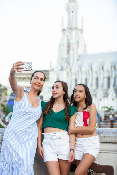 touristen machen ein selfie an der ortiz-brücke mit der kirche la ermita im hintergrund der stadt cali in kolumbien - ermita stock-fotos und bilder