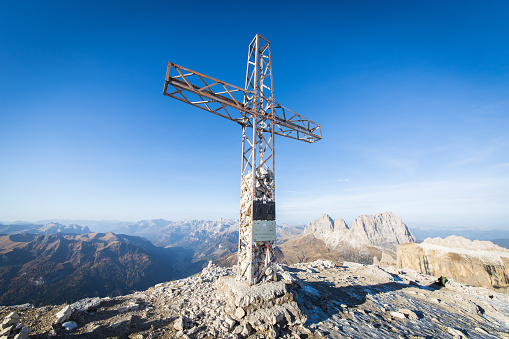 The mountain cross on the sumit of Sass Pordoi on a beautiful autumn day with perfect hiking conditions