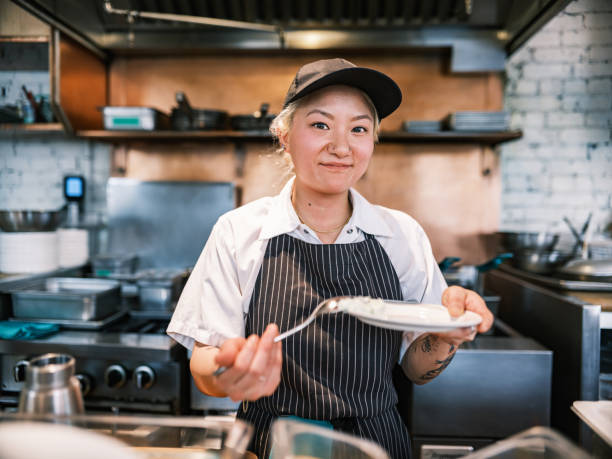 istock Young Korean female chef working in restaurant bar kitchen 1453364146