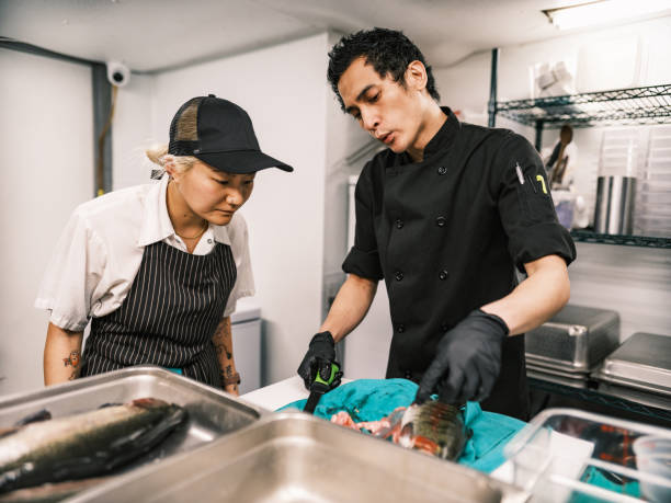 dois jovens chefs que trabalham na cozinha do restaurante - asian ethnicity chef fine dining creativity - fotografias e filmes do acervo