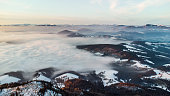 Aerial view of fog covered landscape during sunset in winter conditions. Locations is north of Graz in Austria with the village Semriach under the fog